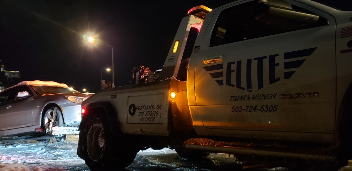 Elite Towing truck responding at night in snowy conditions