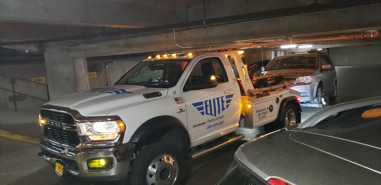 Elite Towing truck working in a parking garage