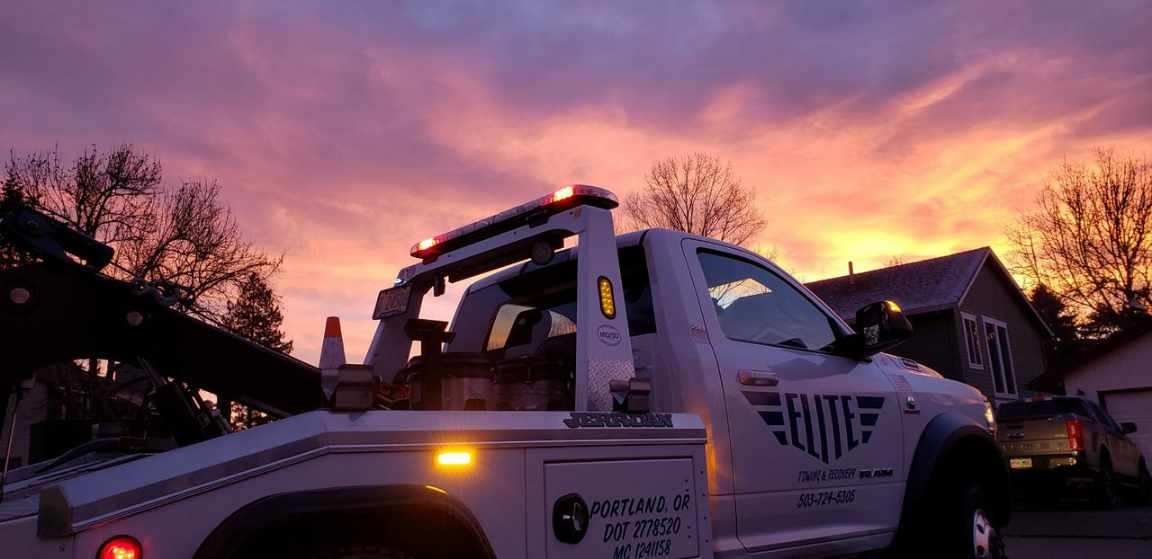 Elite Towing truck against a dramatic sunset sky